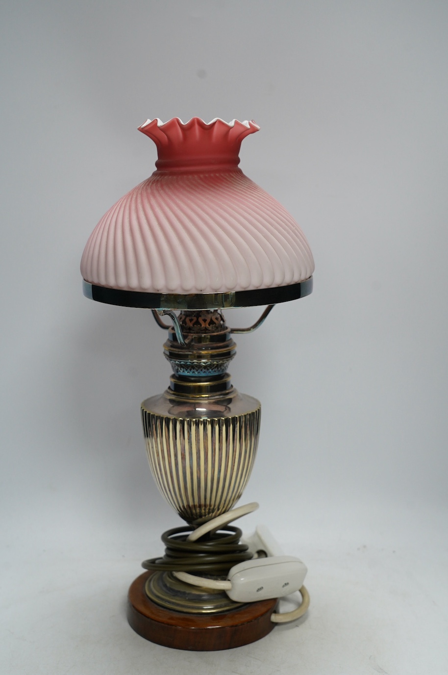 A silver plated table lamp, with a pink satin glass wrythen fluted shade, 41cm high. Condition - shade cracked, lamp untested